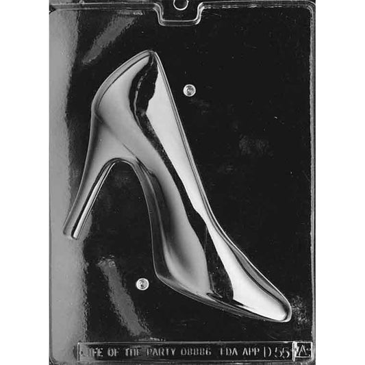 Clear plastic chocolate mold photographed on a dark background showing one half of a large high heel pump cavity with a pointed toe and tall heel.