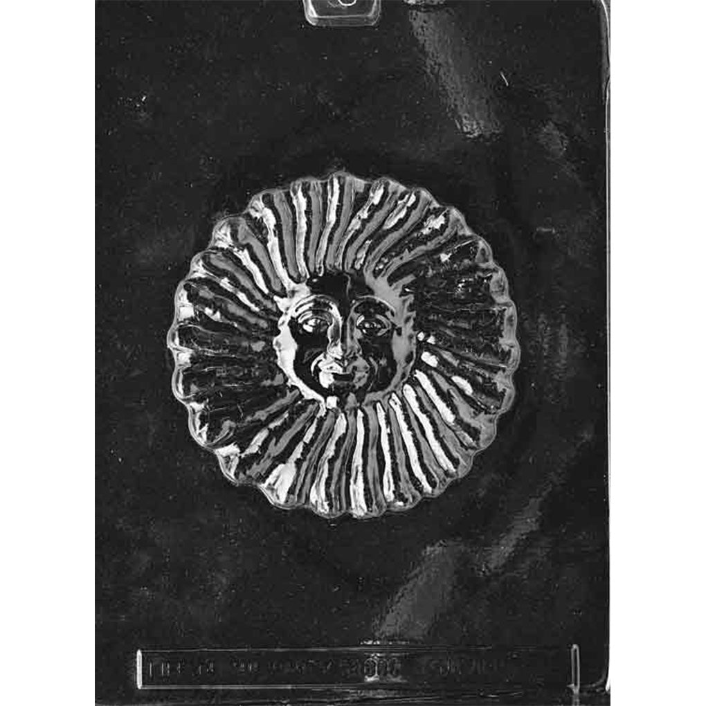 Clear plastic large sunface chocolate mold with one round cavity featuring a smiling face in the center and raised, wavy sun rays around the edge on a dark background.