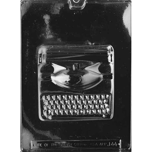 Clear plastic chocolate mold photographed on a black background with one large cavity shaped like a vintage typewriter, showing raised key and carriage details.