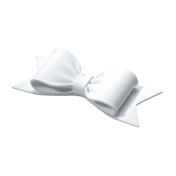 Angled view of a sculpted white gum paste bow showing three-dimensional curves and ribbon tails.