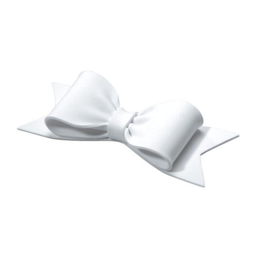 Angled view of a sculpted white gum paste bow showing three-dimensional curves and ribbon tails.