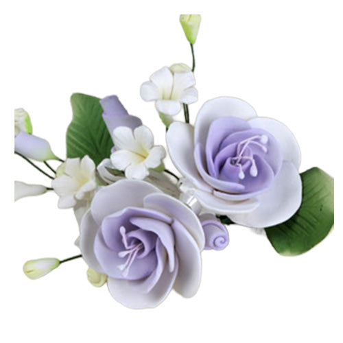 Lavender dog rose gum paste flower spray with two pale purple rose blooms, small white blossoms, green leaves, and buds on wired stems.