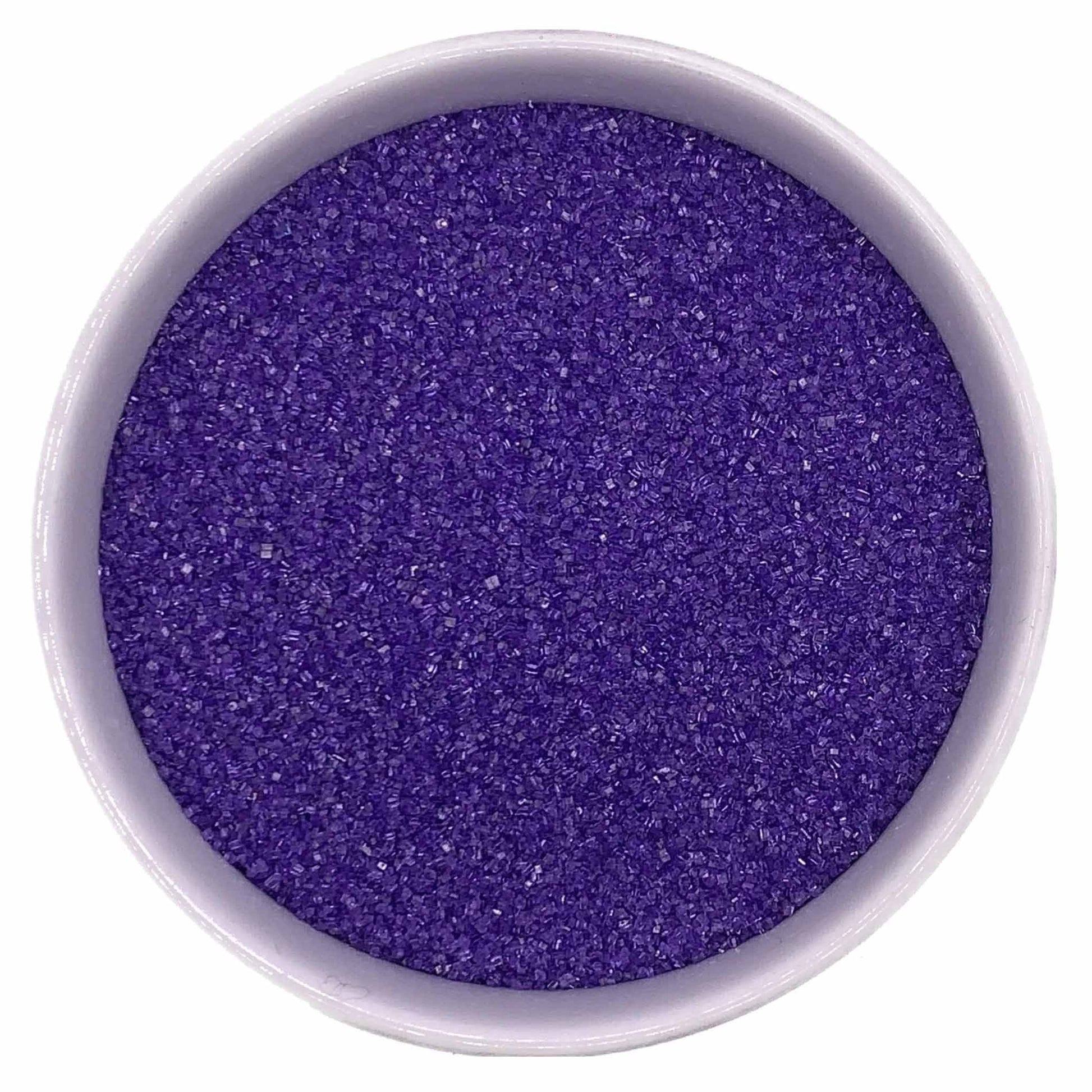 Top-down view of a white bowl filled with lavender fine sanding sugar, showing tiny sparkling crystals in a soft purple-lavender shade.