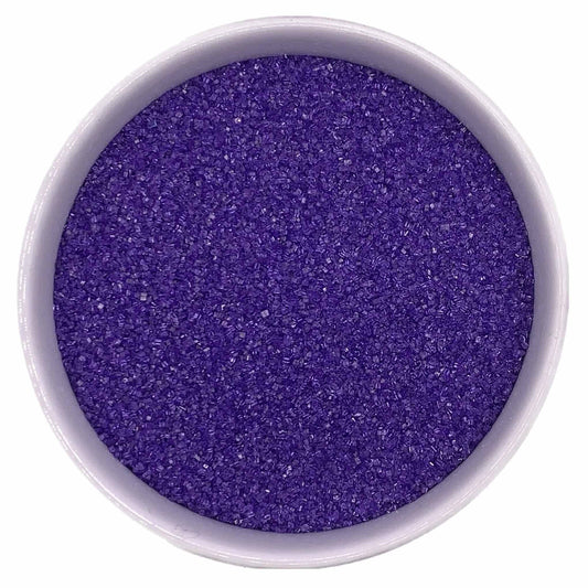 Top-down view of a white bowl filled with lavender fine sanding sugar, showing tiny sparkling crystals in a soft purple-lavender shade.