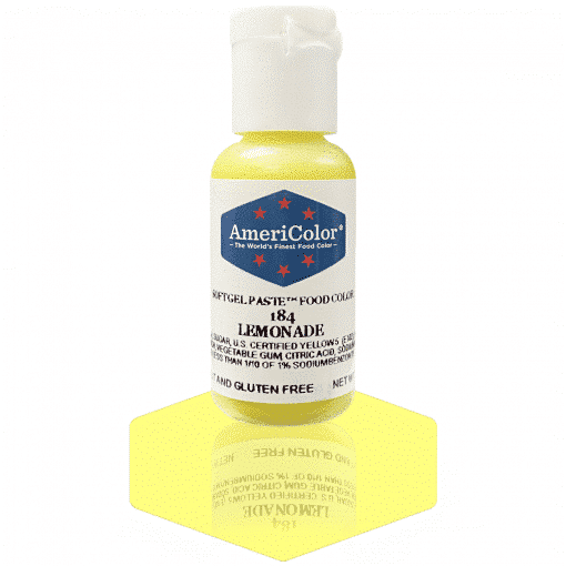 A bottle of AmeriColor Lemonade soft gel paste food coloring with a white cap, blue label, and red stars, standing on a rich yellow-colored reflective surface that mirrors the bottle.