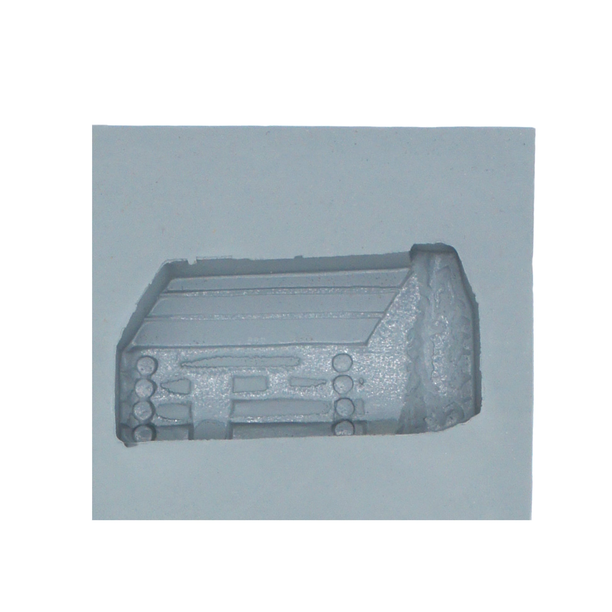 Close-up of log cabin rubber mint mold cavity with stacked log and pitched roof detailing for rustic-themed candy making