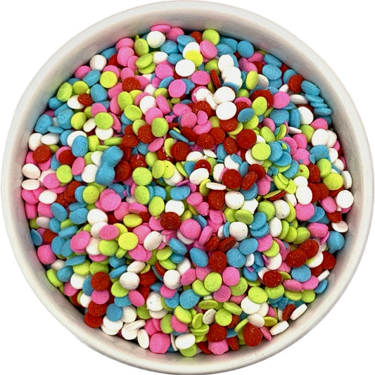 Colorful round mini quin sprinkles in pink, blue, lime green, white, and red, shown in a white bowl.