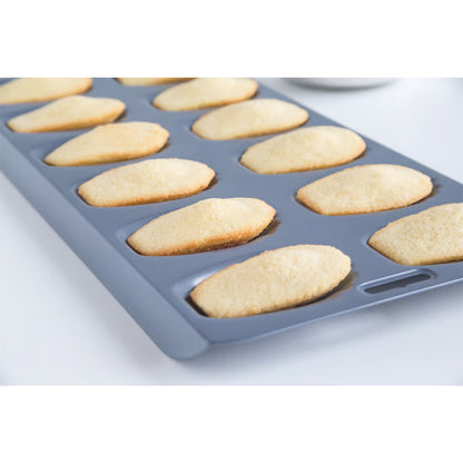 Madeleine pan filled with golden baked madeleines, fresh from the oven, showing uniform shape and texture.