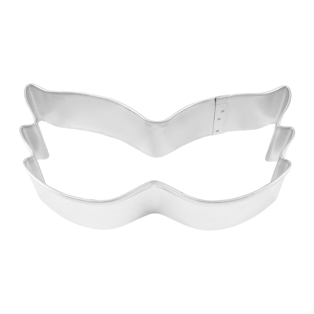 Top-down view of a Mardi Gras mask cookie cutter with a winged, masquerade-inspired shape.