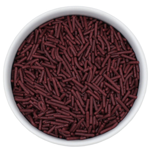 Top-down close-up of a white bowl filled with maroon jimmies sprinkles.