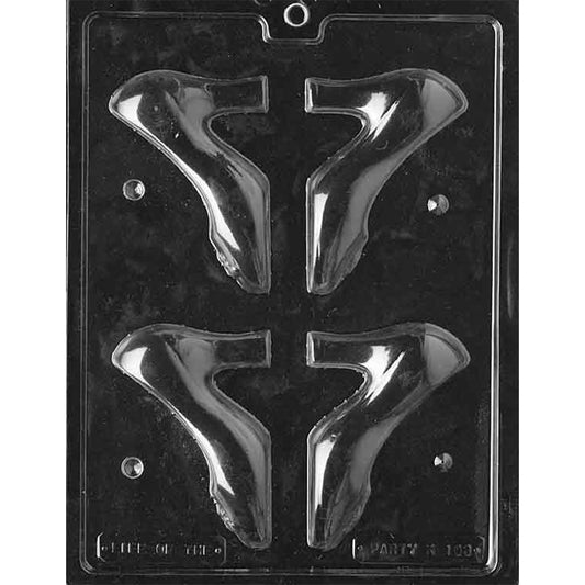 Clear plastic chocolate mold photographed on a dark background with four medium high heel shoe-shaped cavities, each forming a 3D pump silhouette with a pointed toe and tall heel.