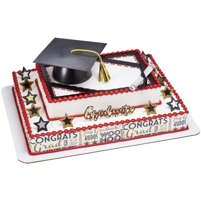 Graduation sheet cake on a larger decorated base, topped with a black mortarboard cap and gold tassel, rolled diploma, and gold “Graduate” pick, with red piped borders, star decorations, and a “Congrats” themed wrap around the bottom tier.