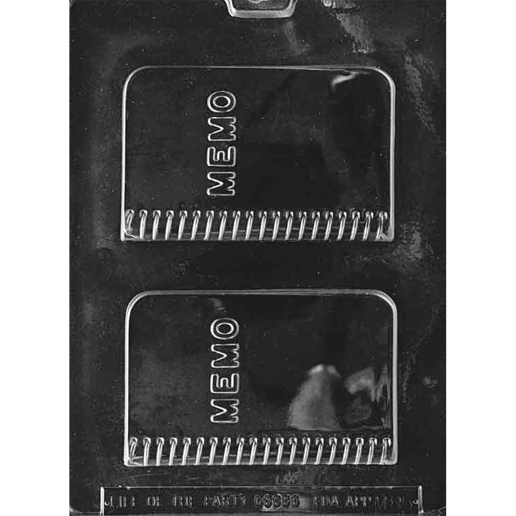 Clear plastic memo book chocolate mold with two rectangular notebook cavities, raised MEMO lettering, and spiral binding