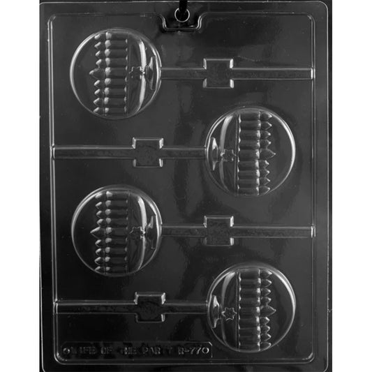 Clear plastic chocolate lollipop mold photographed on a black background, featuring four round lollipop cavities embossed with a menorah design and connected stick channels.