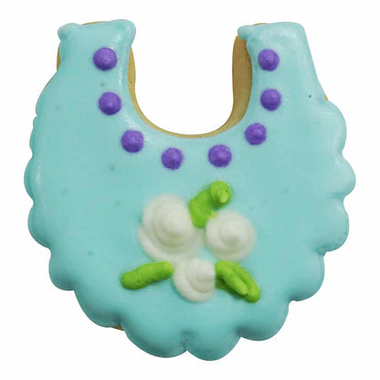 Blue baby bib-shaped cookie decorated with purple polka dots and white floral details.