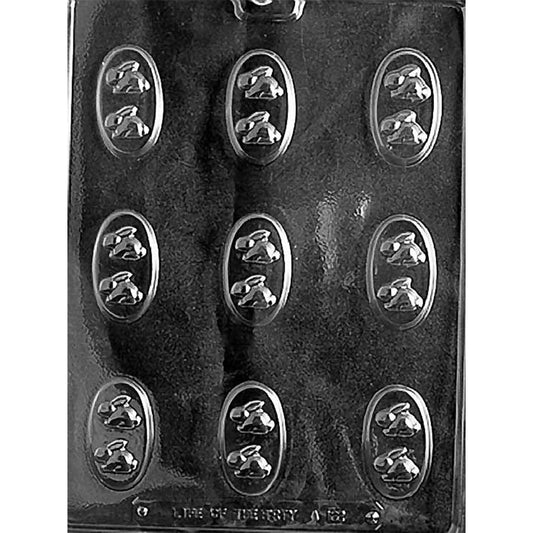Clear chocolate mold with nine small oval cavities, each featuring two tiny bunny shapes, arranged in three rows on a dark background.