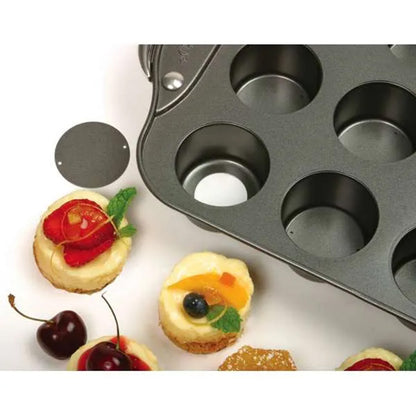 Close-up of the mini cheesecake pan cups showing the removable bottom disk and surrounding mini desserts.