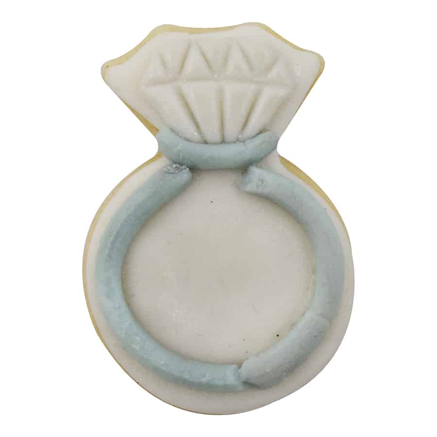 Decorated engagement ring-shaped cookie with white icing for the diamond and light blue icing for the band, made using the Mini Diamond Ring Cookie Cutter.