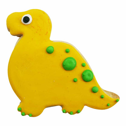 Decorated baby brontosaurus cookie with yellow icing, green spots, and a small black-and-white eye.