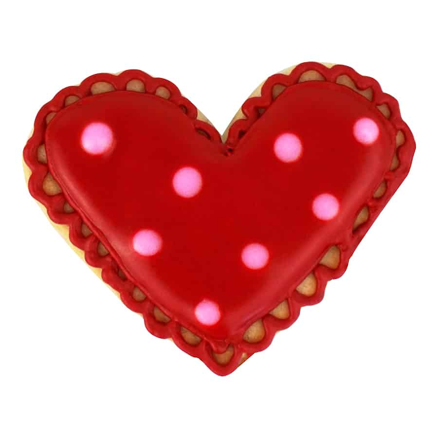 Red heart-shaped cookie with scalloped edges, polka dots, and intricate icing details.