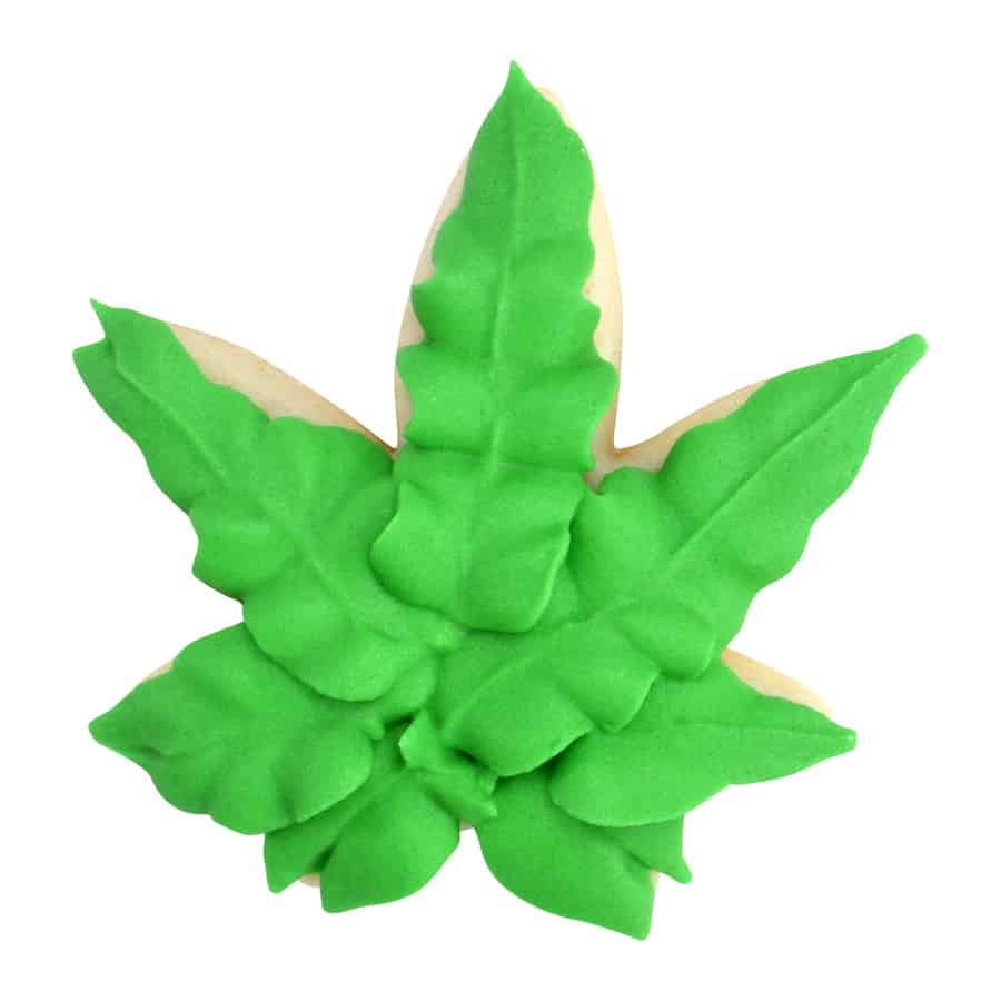 Decorated cookie in the shape of a marijuana leaf, covered in green icing with textured details.