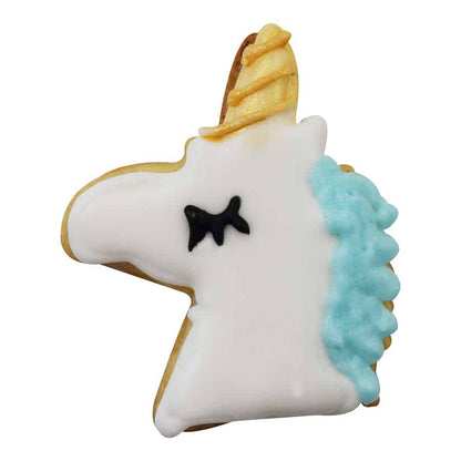 Decorated unicorn-shaped cookie with white icing, a golden horn, and a blue mane.