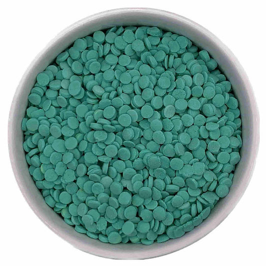 Close-up of flat round mint green and teal Confetti Quinn Sprinkles in a white bowl, sold in a 4 oz. package