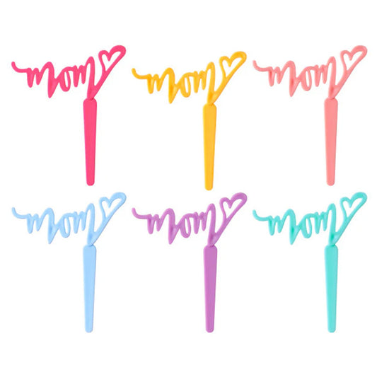 Mixed-color “MOM” heart cupcake picks arranged on a white background.