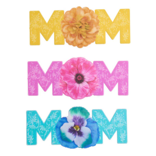 Three MOM cake toppers shown in yellow, pink, and blue, each with a large flower in the center and subtle leaf patterns on the letters.