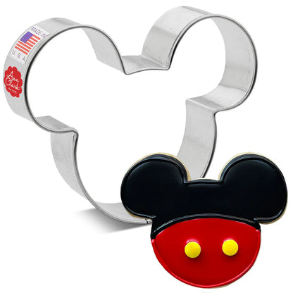 Mouse head cookie cutter alongside a decorated cookie with black and red icing and two yellow buttons.