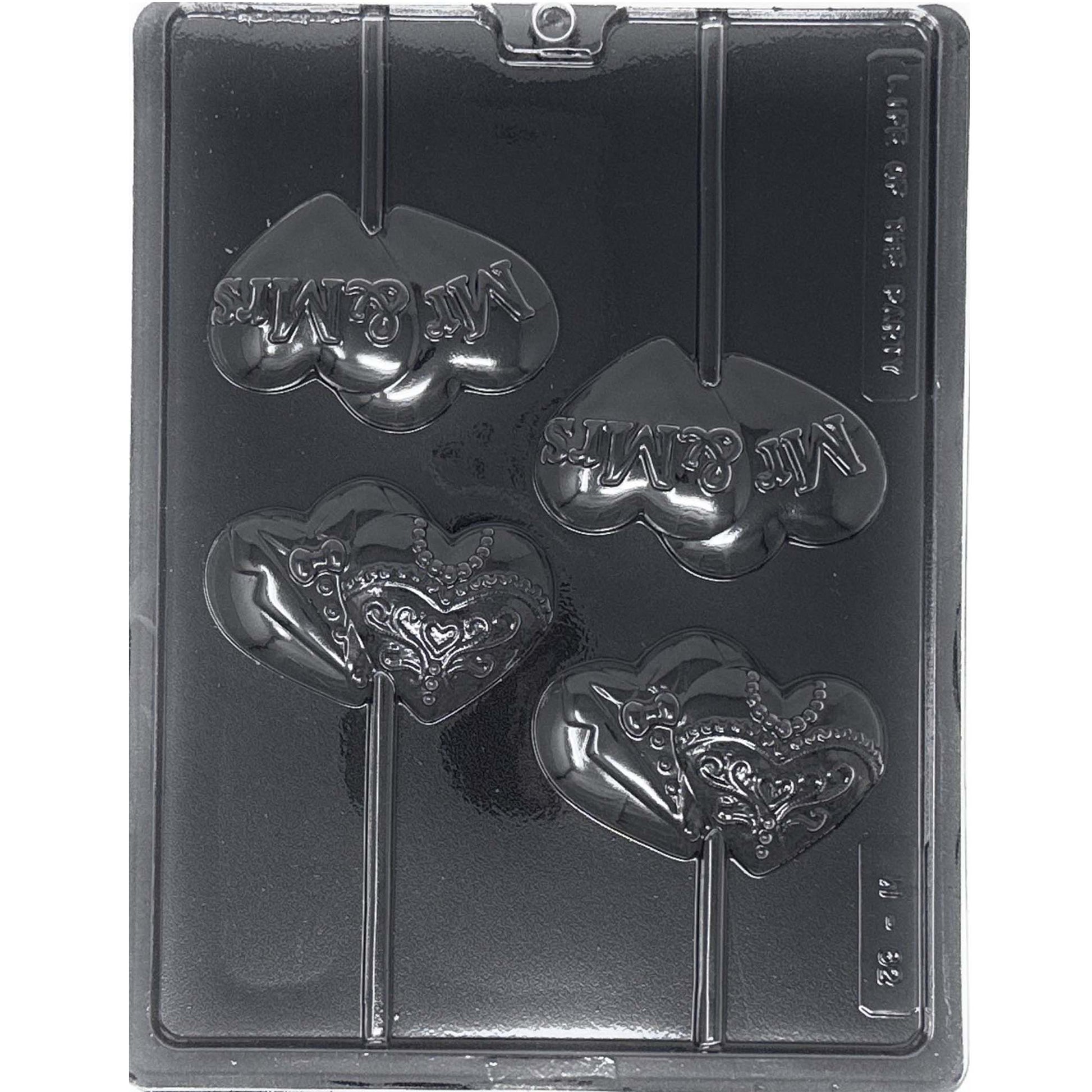 Clear Mr & Mrs wedding chocolate lollipop mold photographed against a black background, with four heart-shaped cavities featuring raised Mr & Mrs lettering and tuxedo and ornate wedding dress designs.