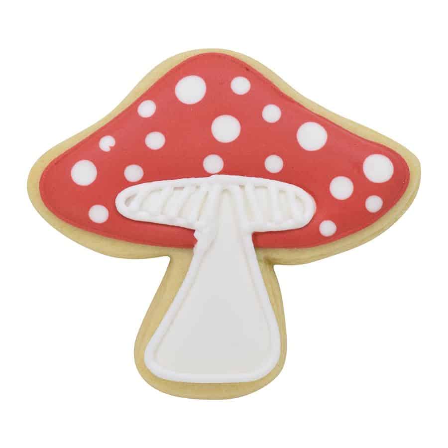 Decorated mushroom-shaped cookie with a red cap, white polka dots, and a detailed stem.