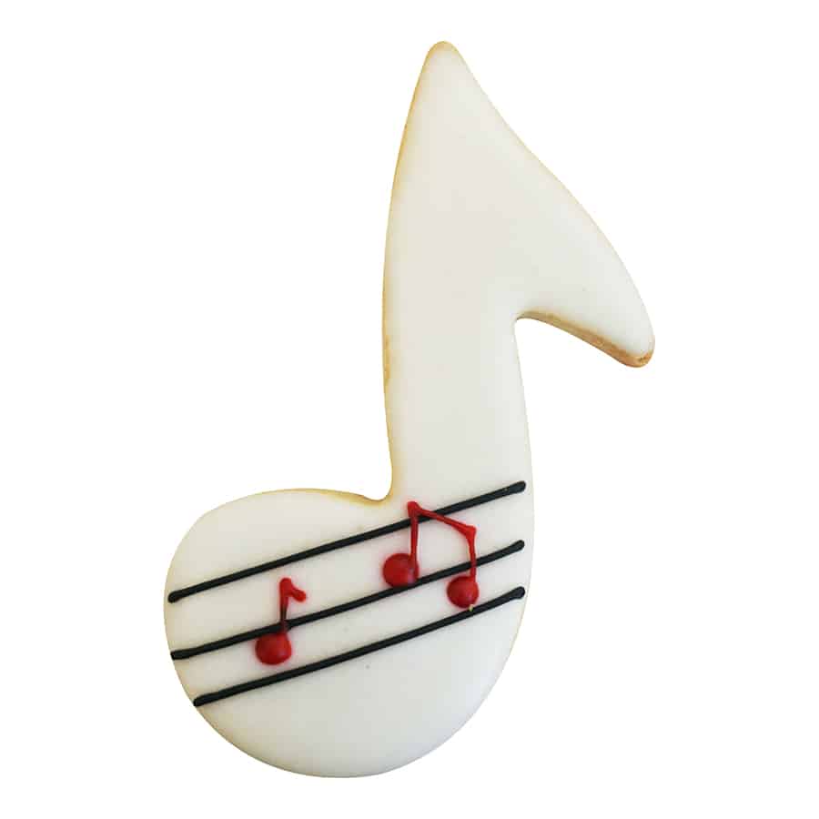 Decorated cookie shaped like a music note with white icing, black music lines, and small red music notes piped on top.