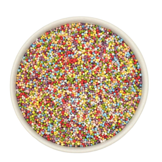 Bowl filled with colorful, natural nonpareils in red, blue, yellow, green, and pink, used for decorating cakes and desserts.
