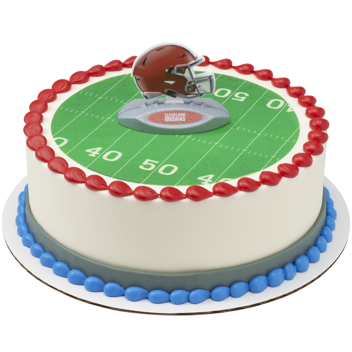A round cake decorated with a green football field print, red piped border, blue base border, and a brown helmet topper on top.