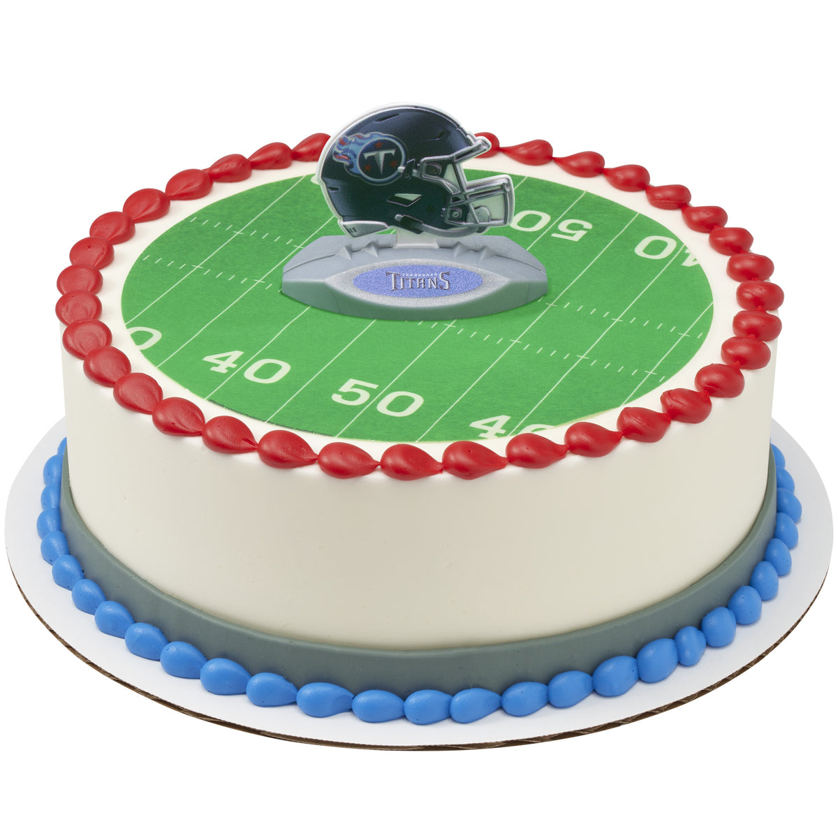 A round cake decorated like a football field, with a green field graphic, white yard lines, red piped border, blue base trim, and a Tennessee Titans helmet topper on top.