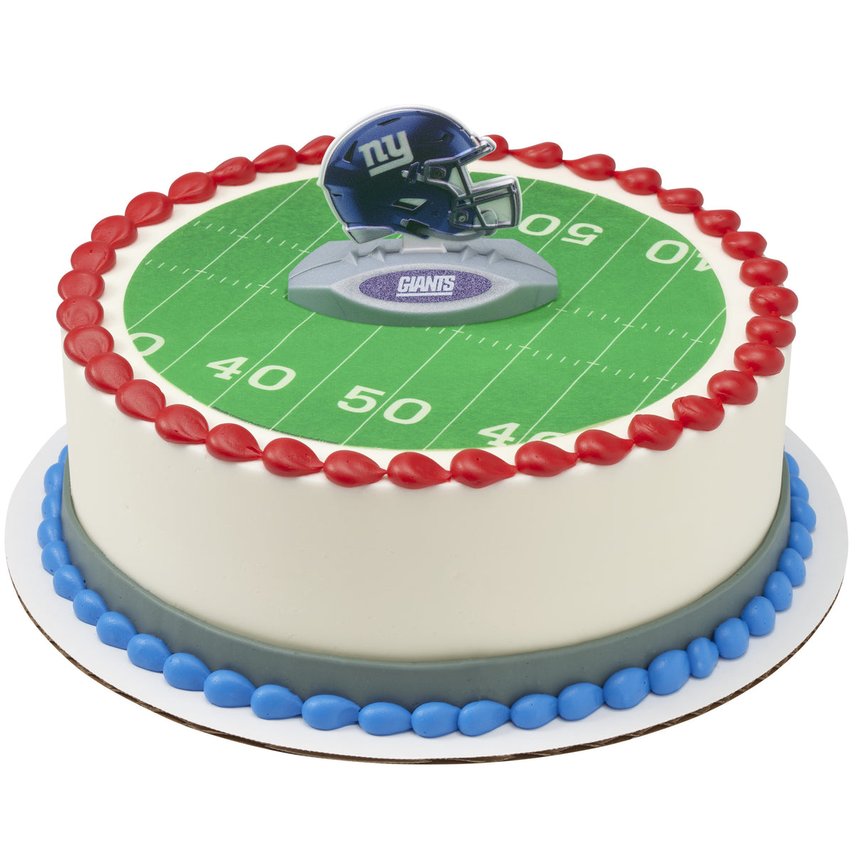 A round cake decorated with a green football field print, red piped border, blue base, and a New York Giants helmet topper on top.