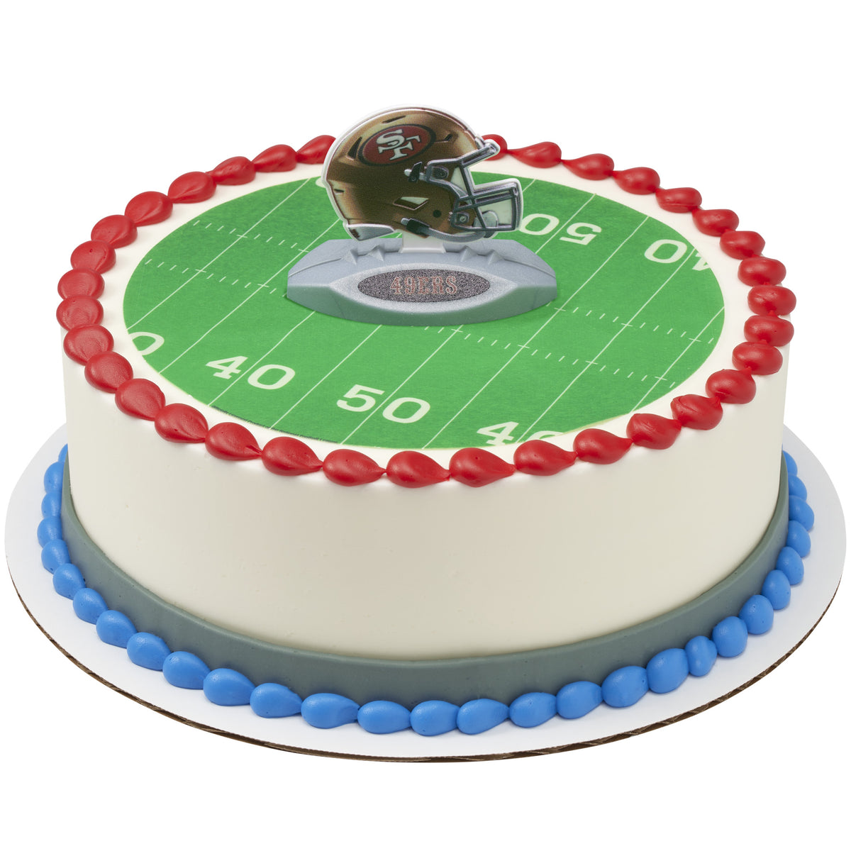 A round cake decorated with a football field design, red piped border, blue base trim, and a small helmet topper on top, shown on a white background.