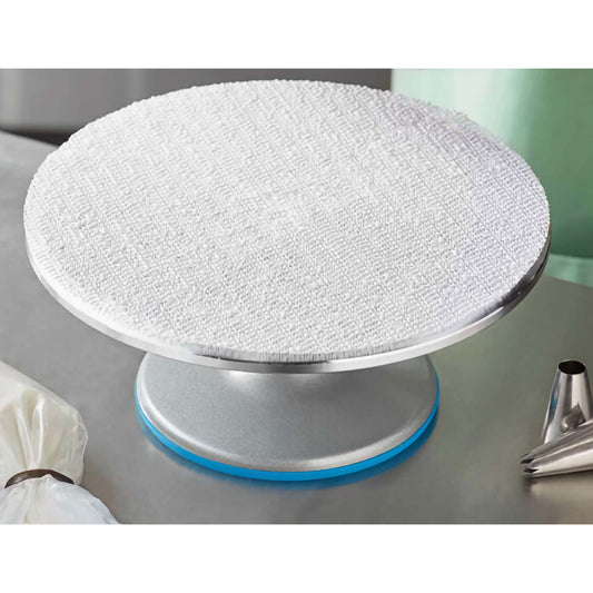 White 12-inch non-slip cake turntable pad positioned on a metal cake decorating turntable.
