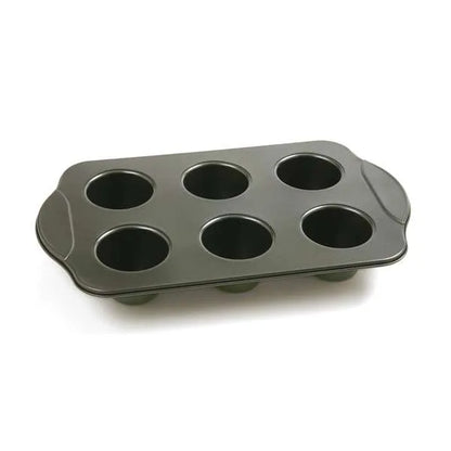 Empty nonstick popover pan with six evenly spaced cavities, perfect for baking tall pastries.