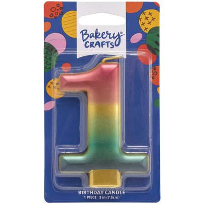 Packaged metallic rainbow number 1 birthday candle with a pink-to-gold-to-green-to-blue gradient and a gold base, on a blue Bakery Crafts card.