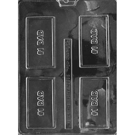 Clear plastic chocolate mold with four rectangular cavities, each featuring raised “#1 Dad” lettering centered inside a bordered plaque shape on a dark background.