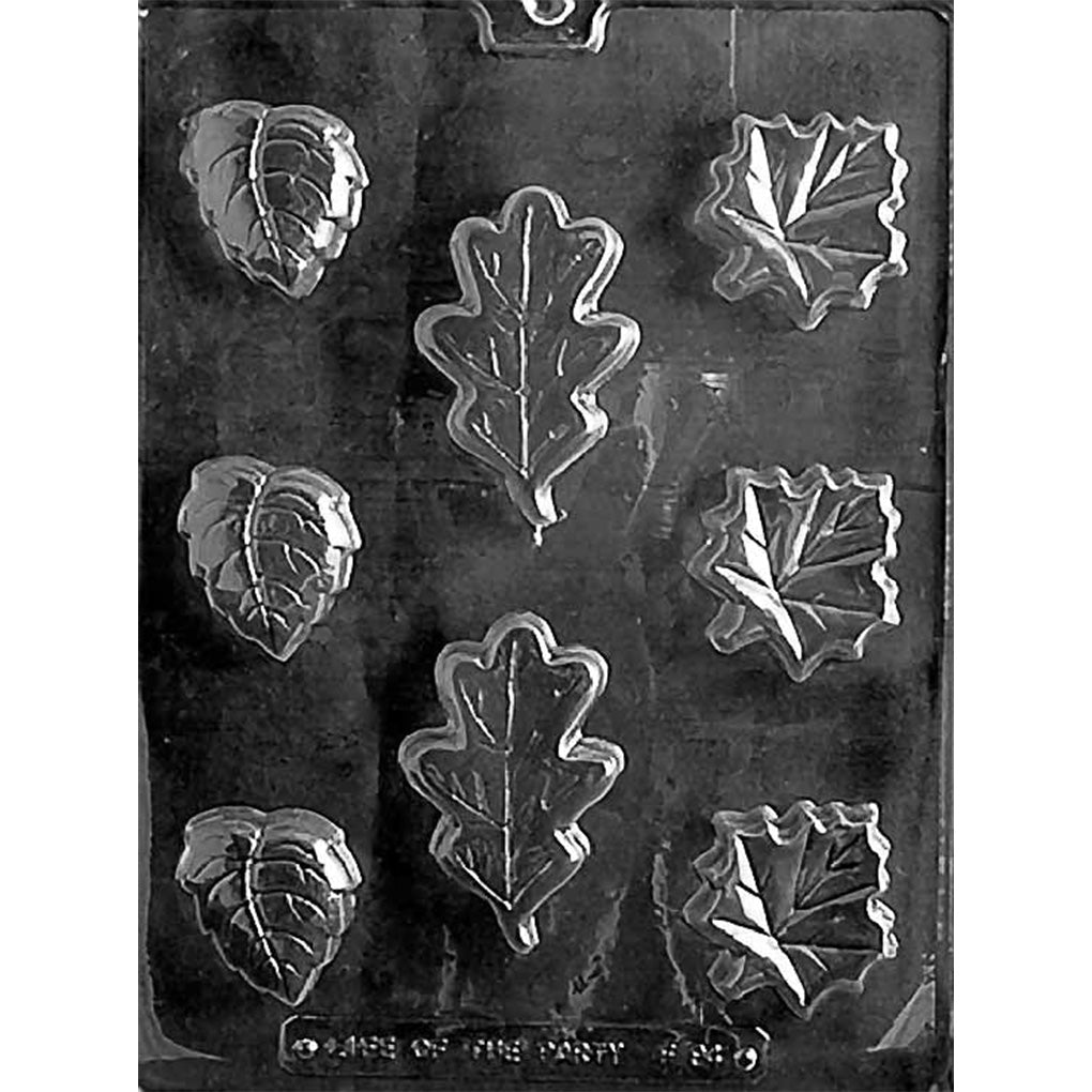 Clear plastic chocolate mold with nine leaf-shaped cavities in three styles, including an oak-like lobed leaf, a pointed oval leaf with veins, and a jagged maple-style leaf.