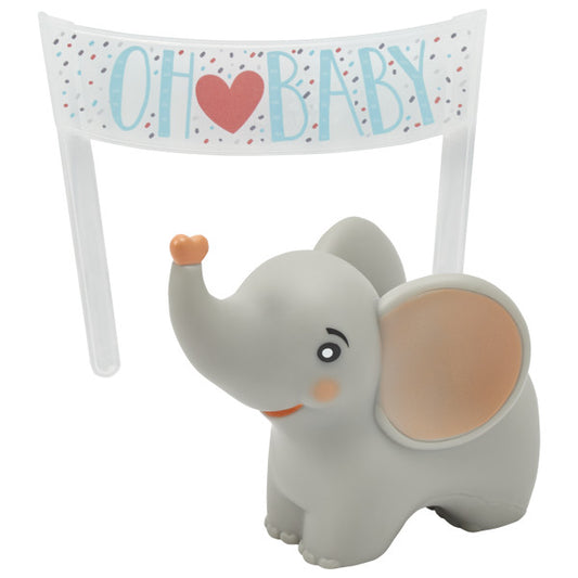 Close-up of baby elephant cake topper with peach-colored ears and a small heart on its trunk, shown with “Oh Baby” banner in the background.