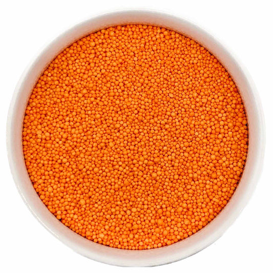 Bowl of bright orange nonpareil sprinkles on a white background.