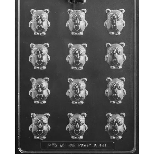 Clear chocolate mold with 12 owl-shaped cavities, each featuring large round eyes and a heart on its chest, photographed on a black background.