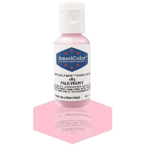 A bottle of AmeriColor Pale Peony soft gel paste food coloring with a white cap, blue label, and red stars, standing on a pink reflective surface that mirrors the bottle.