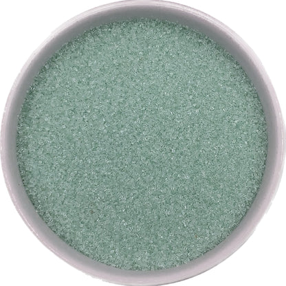 Bowl of pastel green sanding sugar for decorating baked goods.