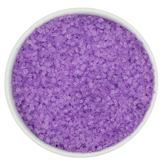 Top-down view of a white bowl filled with pastel purple coarse sanding sugar crystals, showing light violet, chunky granules with a clear sparkling shine.