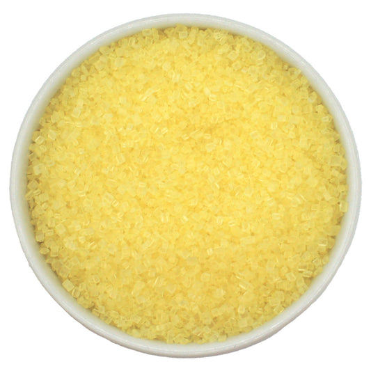 Bowl of pastel yellow coarse sanding sugar crystals on a white background.